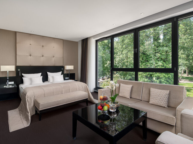Bett und Couch vor dem großen Panoramafenster